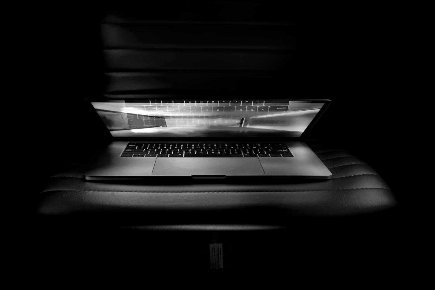 Students engaged in blockchain development workshop with multiple monitors showing code and network diagrams