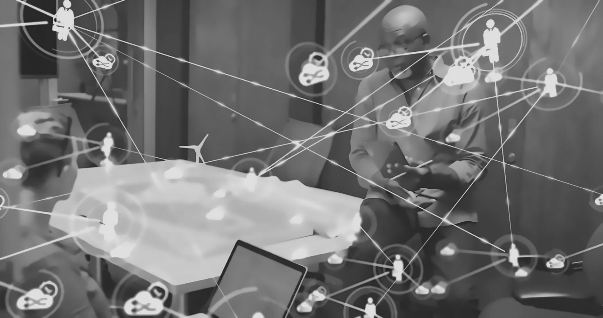 Group of diverse professionals collaborating around a table with blockchain diagrams and laptops